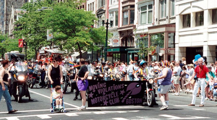 People during the 2001 Boston Pride Parade holding a banner that reads Moving Violations Motorcycle Club