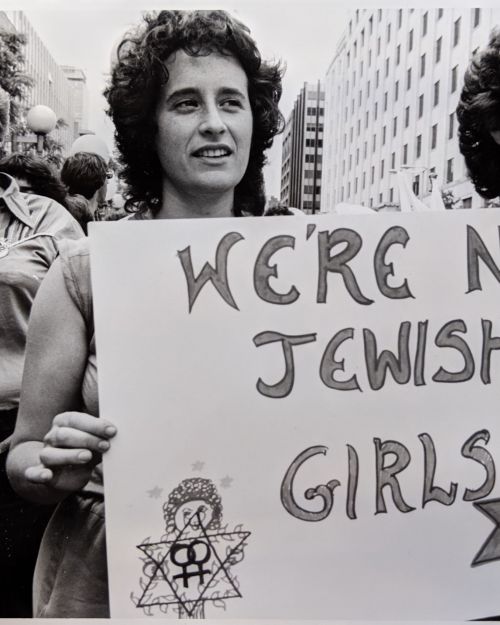 Two women holding a sign that reads We're Nice Jewish Girls during the 1980 Boston Pride March