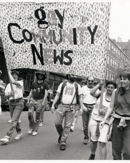 Men and women of Gay Community News holding a large banner in the 1990 Pride march in Boston. Credit: Susan Fleischmann