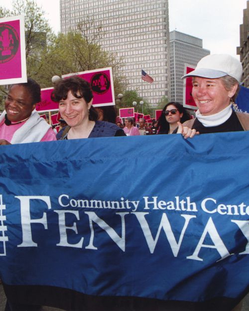 The marchers carry a Fenway Community Health Center banner and signs for the Massachusetts Breast Cancer Coalition. Courtesy of Fenway Community Health Center